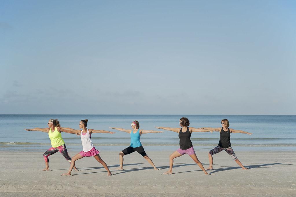Cours de yoga en groupe sur la plage