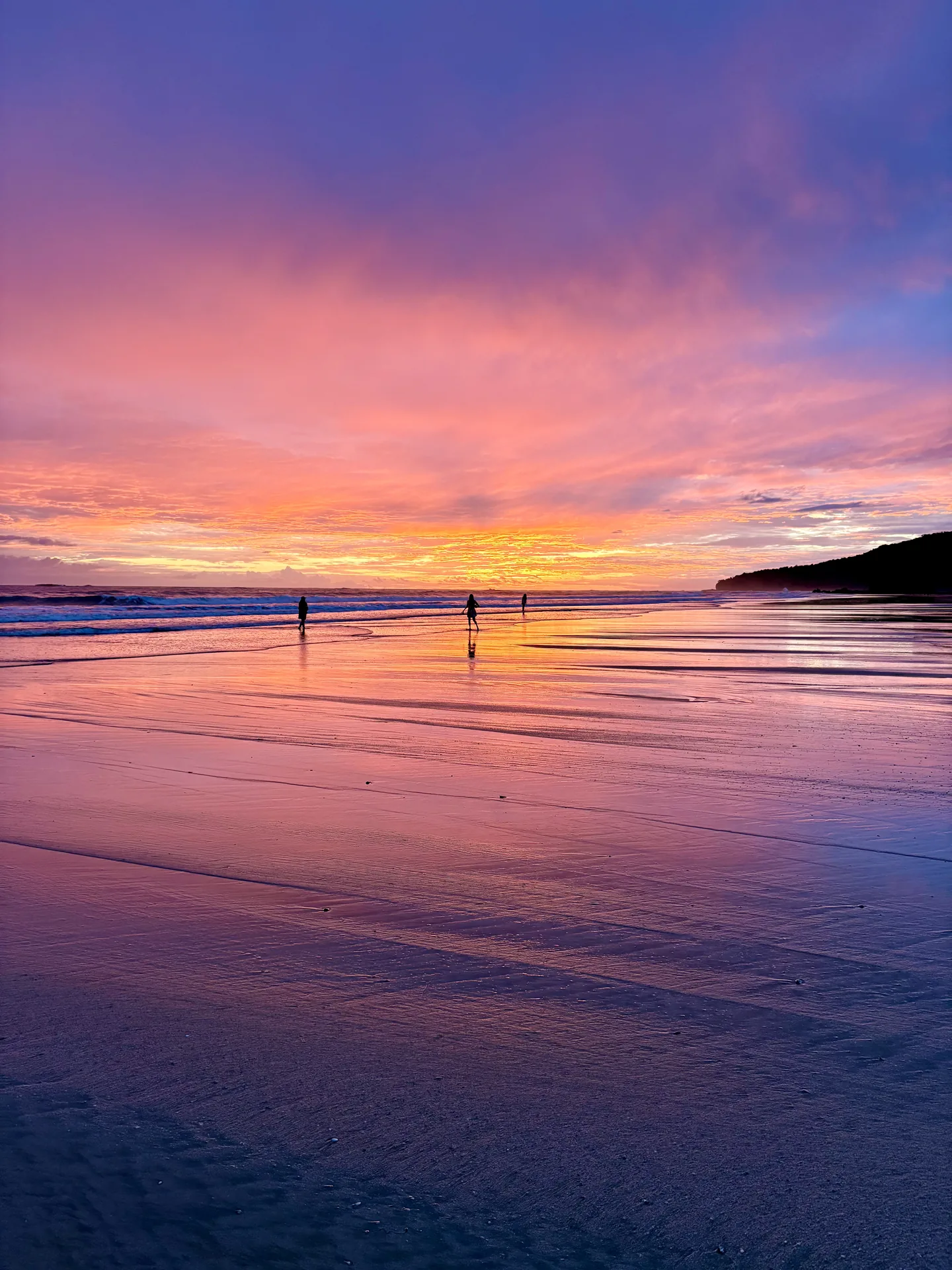 Pink sky over the wet sand at low tide