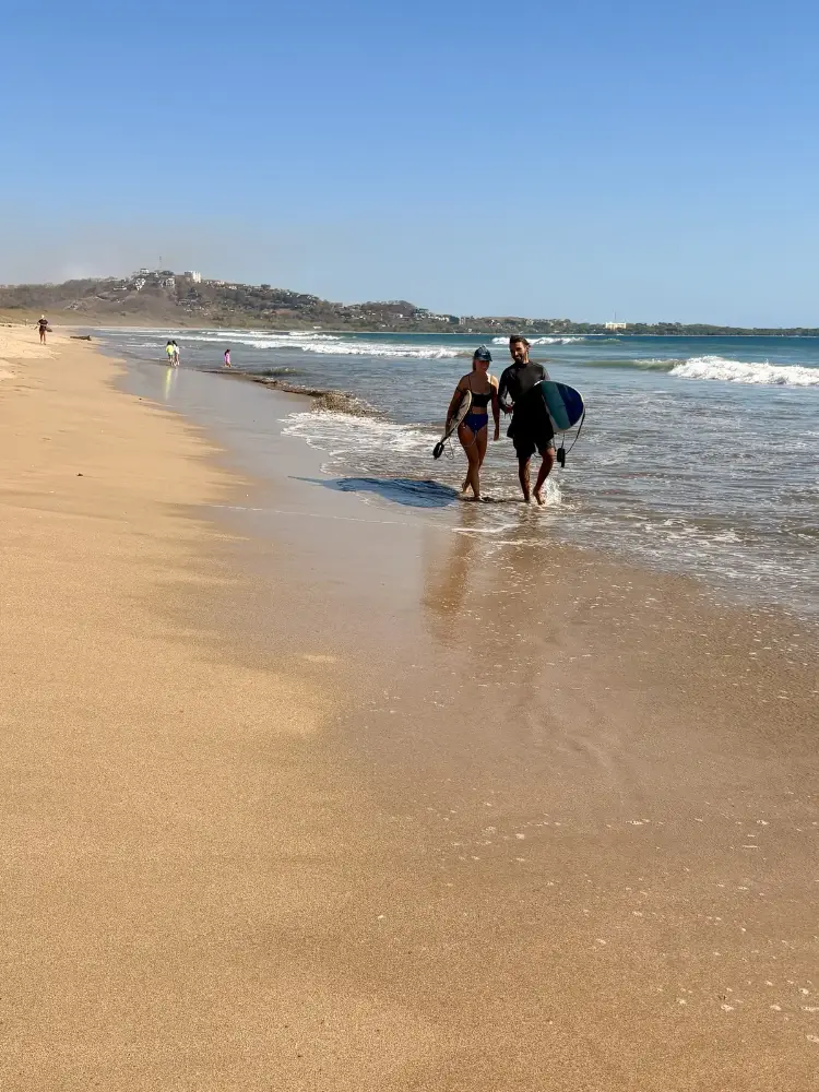 Deux surfeurs marchant sur Playa Grande avec leurs planches