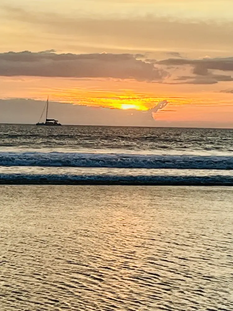 Catamaran naviguant devant Playa Grande au coucher du soleil